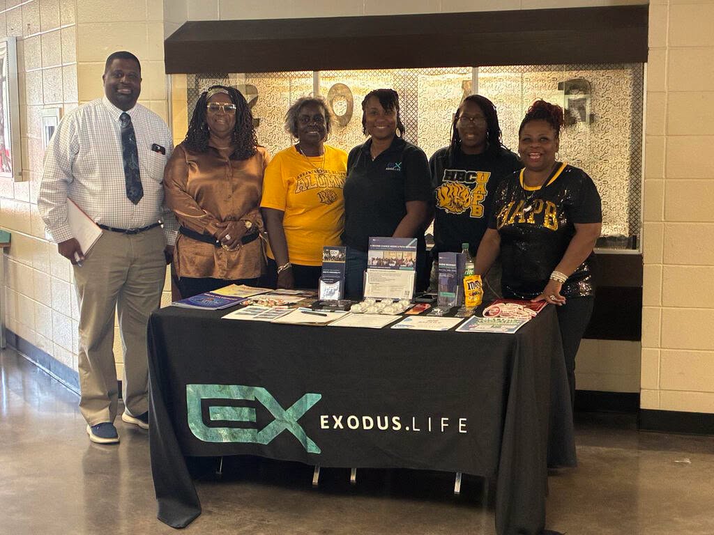 Community partners gathered behind an educational outreach table at Exodus Life